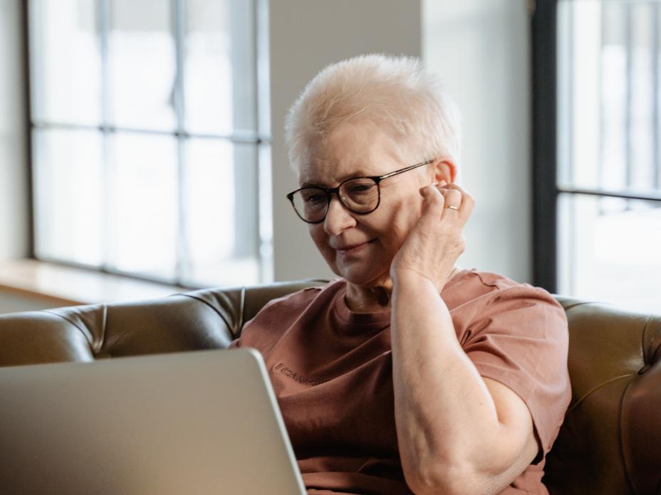 A woman sitting on the couch using a laptop