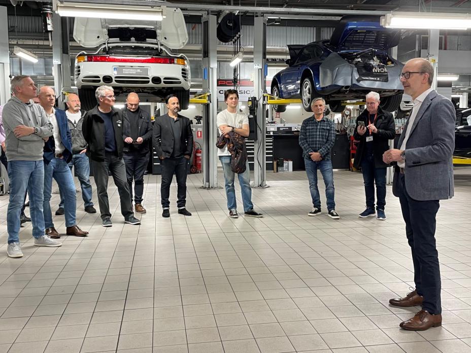 A group of men standing in a car manufacturing plant