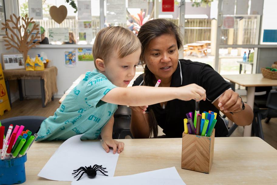 Female childcare worker drawing with a child